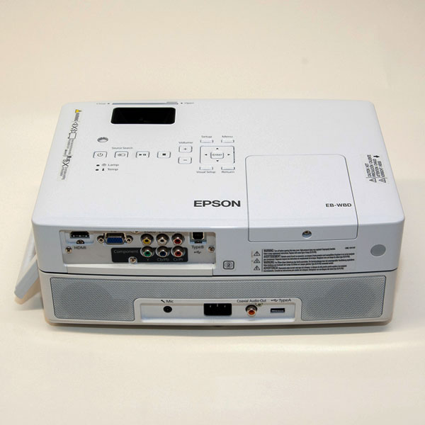 Weißer Epson EB-W8D Beamer mit verschiedenen Anschlüssen auf der Rückseite, darunter HDMI, VGA, Composite und Audioanschlüsse.