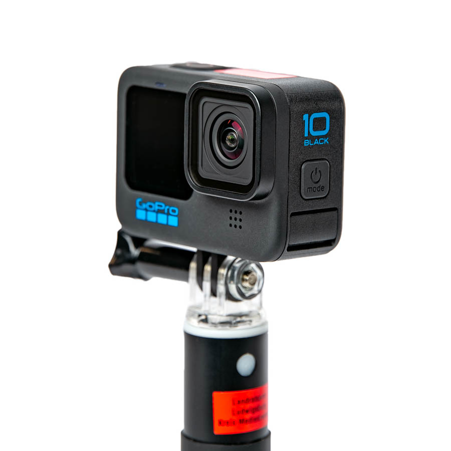 Schwarze GoPro Hero 10 Black Actionkamera auf Halterung mit sichtbarem Objektiv und blauer Beschriftung.