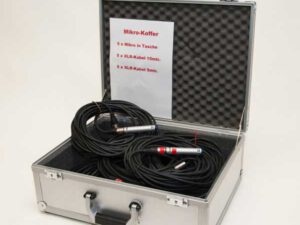 Offener silberner Mikrofonkoffer mit gepolstertem Deckel, zwei aufgerollten XLR-Kabeln mit Steckern sichtbar.