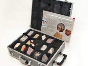 Offener Geo-Koffer mit mehreren Gesteinsproben in Fächern und einer Infokarte zum Travertin im Deckel.