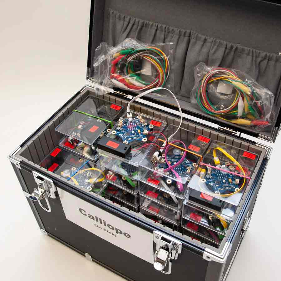 Offener schwarzer Transportkoffer mit mehreren transparenten Kunststoffboxen, darin elektronische Platinen und bunte Kabel, zwei Kabelbündel in Plastiktüten im Deckel, Aufkleber mit 'Calliope' am Koffer.