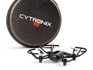 Kleine schwarze Drohne mit Schutzrahmen und Kamera vor rundem schwarzen Transportetui mit weißer Aufschrift 'CYTRONIX'.