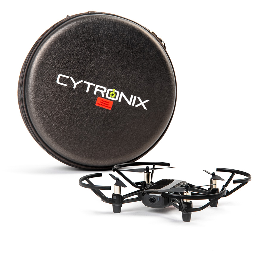 Kleine schwarze Drohne mit Schutzrahmen und Kamera vor rundem schwarzen Transportetui mit weißer Aufschrift 'CYTRONIX'.