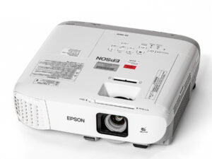 Weißer Epson-Beamer mit Objektiv und Lüftungsgitter, Modell EB-980W, von schräg oben fotografiert.