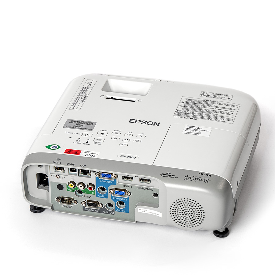 Weißer Epson-Beamer mit zahlreichen Anschlüssen auf der Rückseite, darunter HDMI, USB, LAN und Audioanschlüsse.