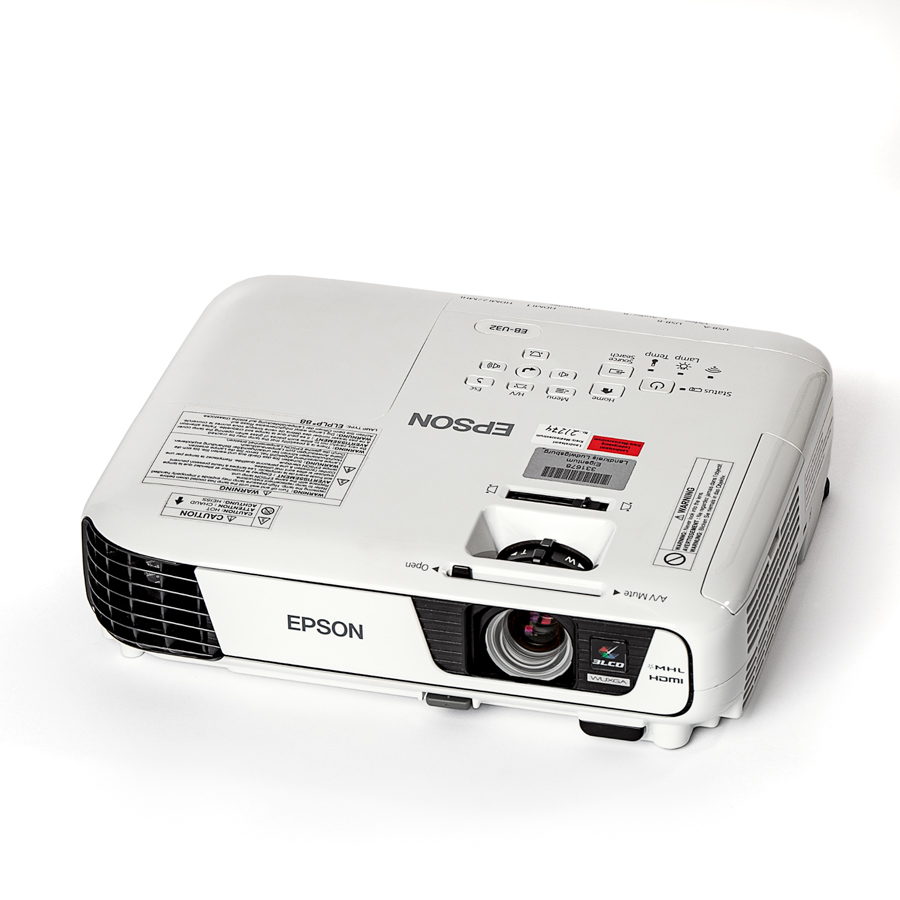 Weißer Epson-Beamer mit sichtbarer Linse und Lüftungsgitter, von oben schräg fotografiert.