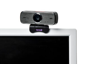 Schwarze Webcam mit silberner Front und mittiger Linse auf weißem Monitorrahmen, Marke 'terra' sichtbar.