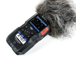 Handheld-Audiorecorder ZOOM H4 essential mit Windschutz aus Fell und mehreren Tasten auf der Vorderseite