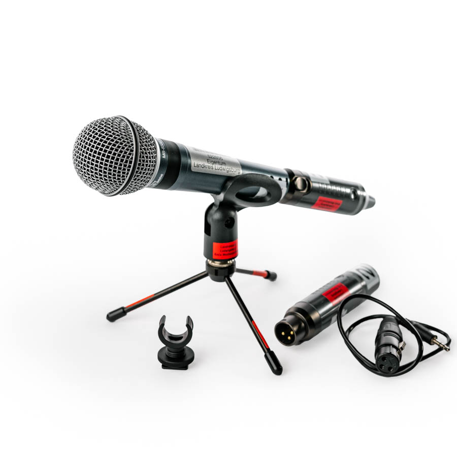 Dynamisches Mikrofon auf kleinem Stativ mit zwei Kabeln und Mikrofonhalterung auf weißem Hintergrund. the_t.bone