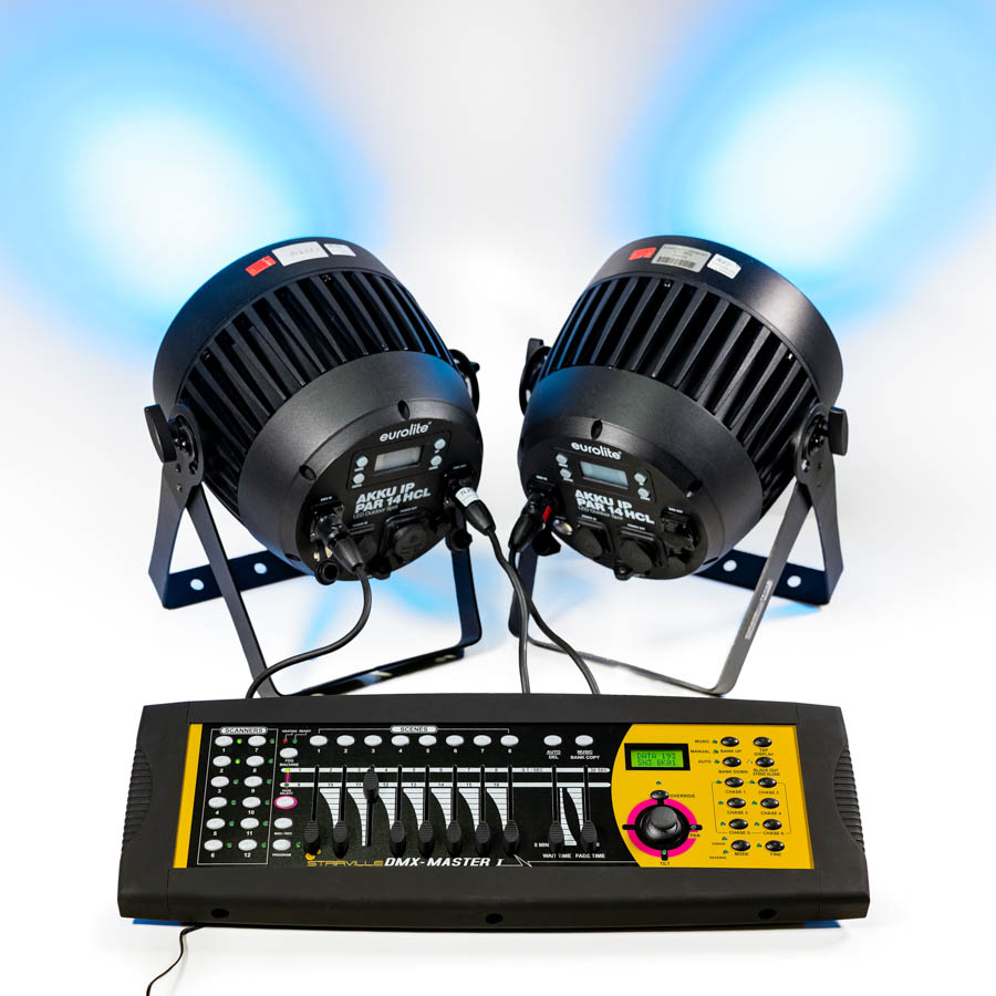 Zwei schwarze Bühnenlichter auf Ständern mit Kabeln, verbunden mit einem schwarzen DMX-Lichtsteuerpult mit Reglern und Display