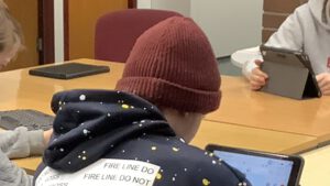 Jugendlicher arbeitet an einem Tablet, Ansicht von Hinten