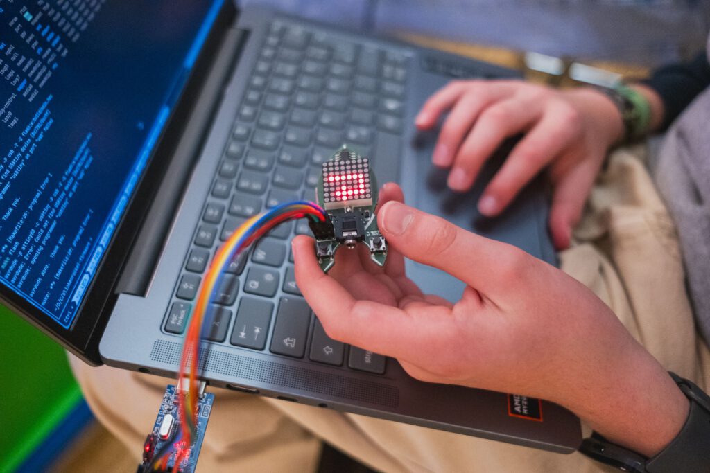 Bild von einer Tastatur und Händen, die eine Platine halten